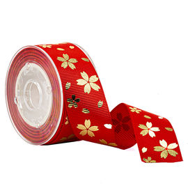 Fiore rosso dell'oro della stagnola sul nastro del Grosgrain stampato rosa per la decorazione di festa