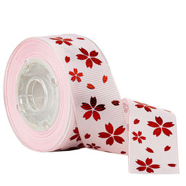 Fiore rosso dell'oro della stagnola sul nastro del Grosgrain stampato rosa per la decorazione di festa