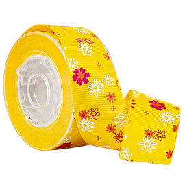 Scatole da pasticceria gialle che avvolgono il nastro del Grosgrain stampato fiore